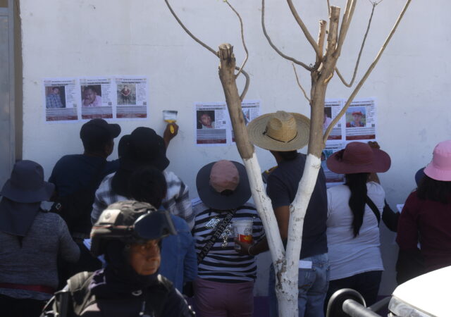 Familiares de desaparecidos pegan fichas de búsqueda en Tlapa