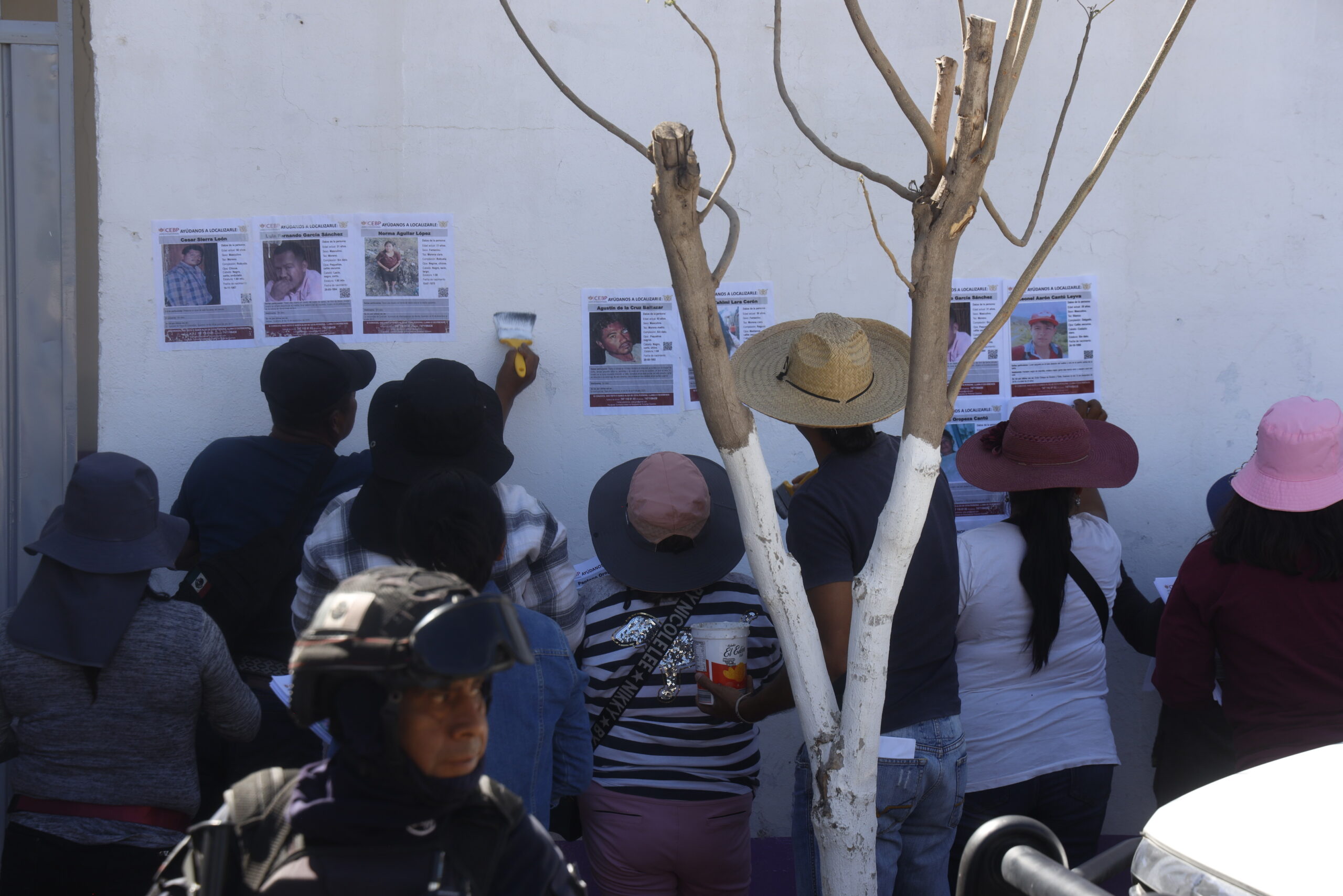 Familiares de desaparecidos pegan fichas de búsqueda en Tlapa